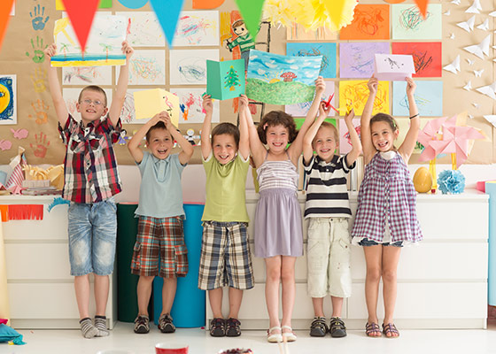 six children holding up drawings that they drew