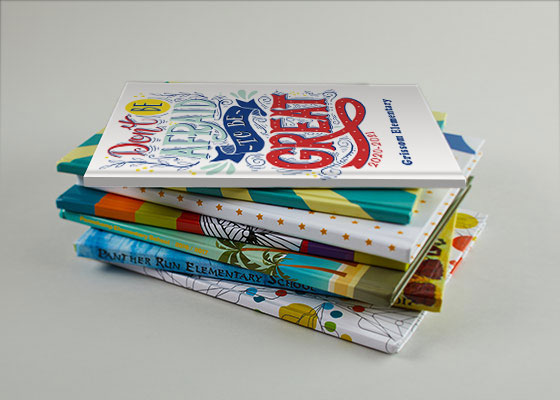 Stack of seven yearbooks on a white background